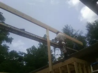 Carpenter setting a ridge beam over a new addition frame — Ice Dam Removal by Roofing Brothers in Juliustown