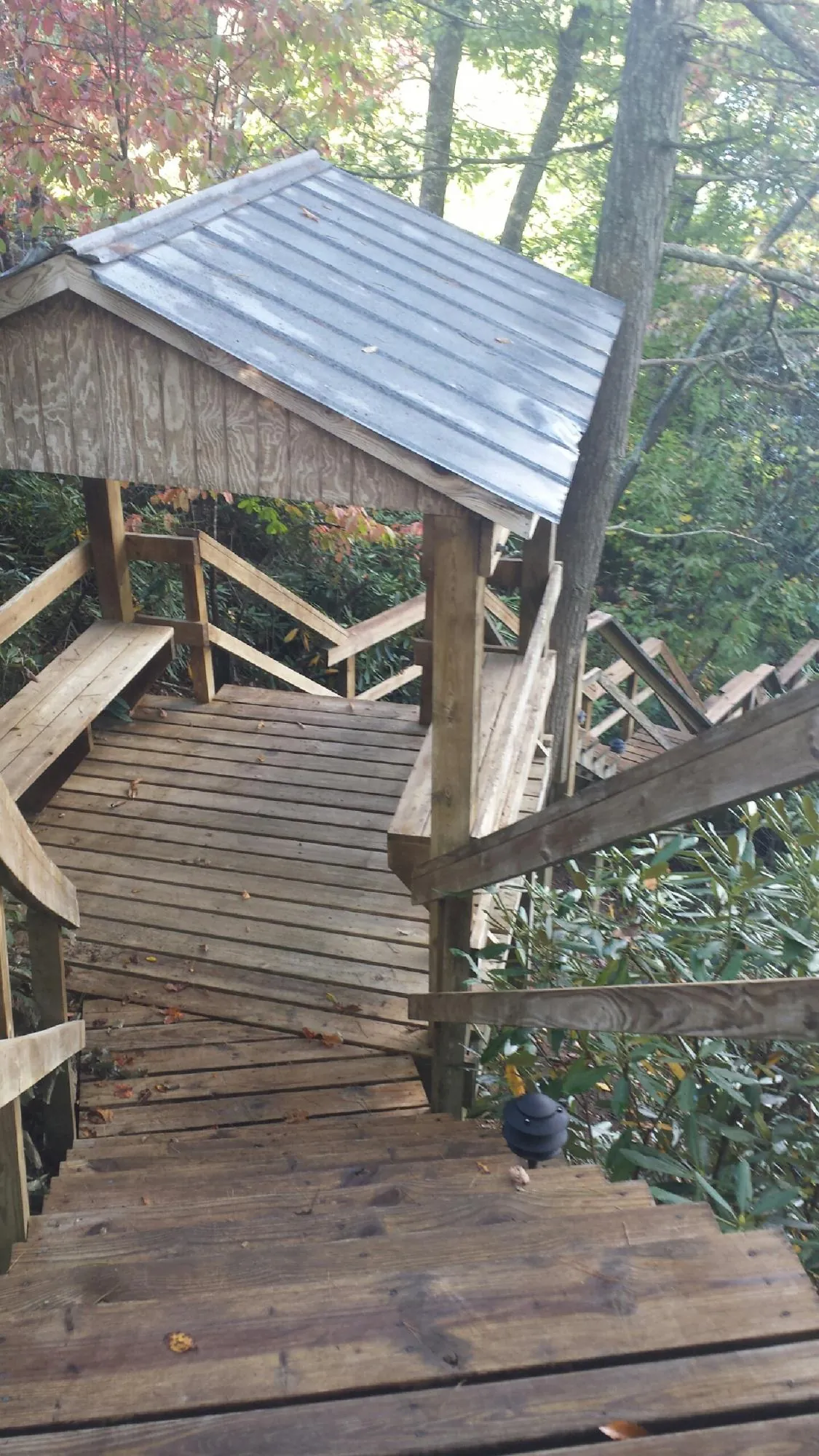 Metal roofed shelter over wooden steps on a wooded walkway — Skylight Repair & Installation work by our crew in Juliustown