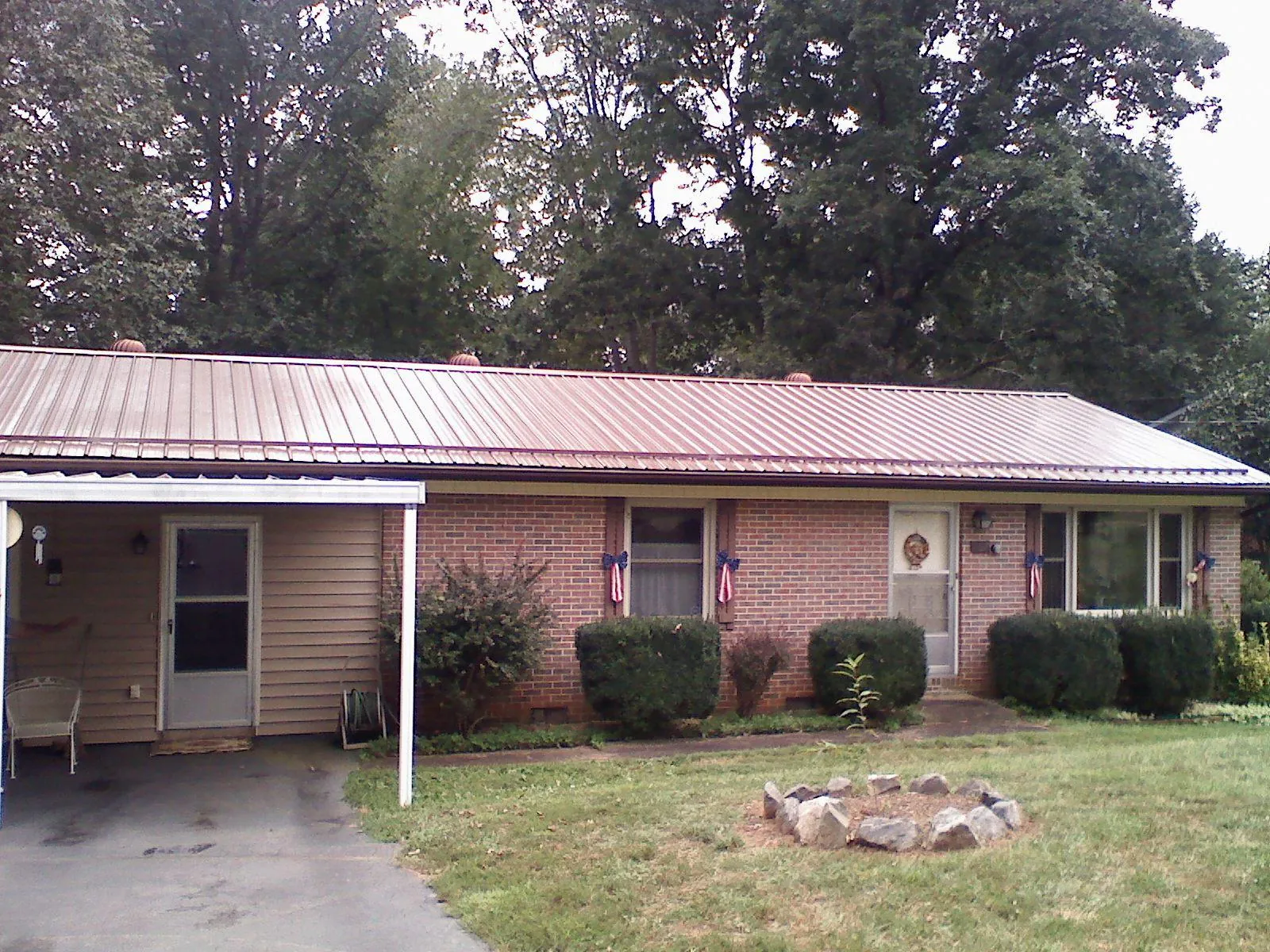 Bronze metal roof and carport on a brick ranch home — Roof Repair work by our crew in Juliustown